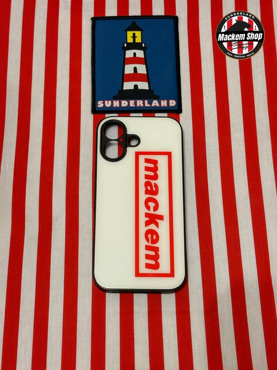 Phone case with 'mackem' branding and a lighthouse design on a red and white striped background.