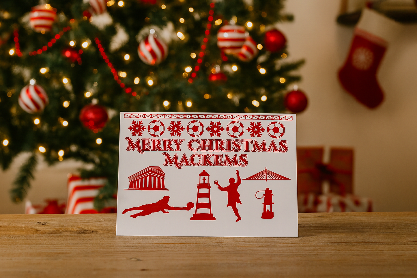 Christmas card with illustrations and text in front of a decorated Christmas tree.