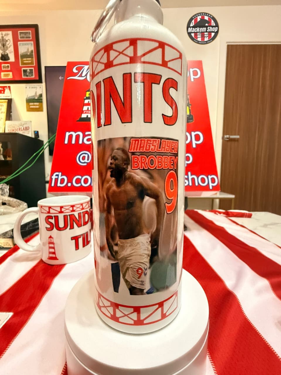 White bottle with red text and a boxer graphic on a red and white striped tablecloth.