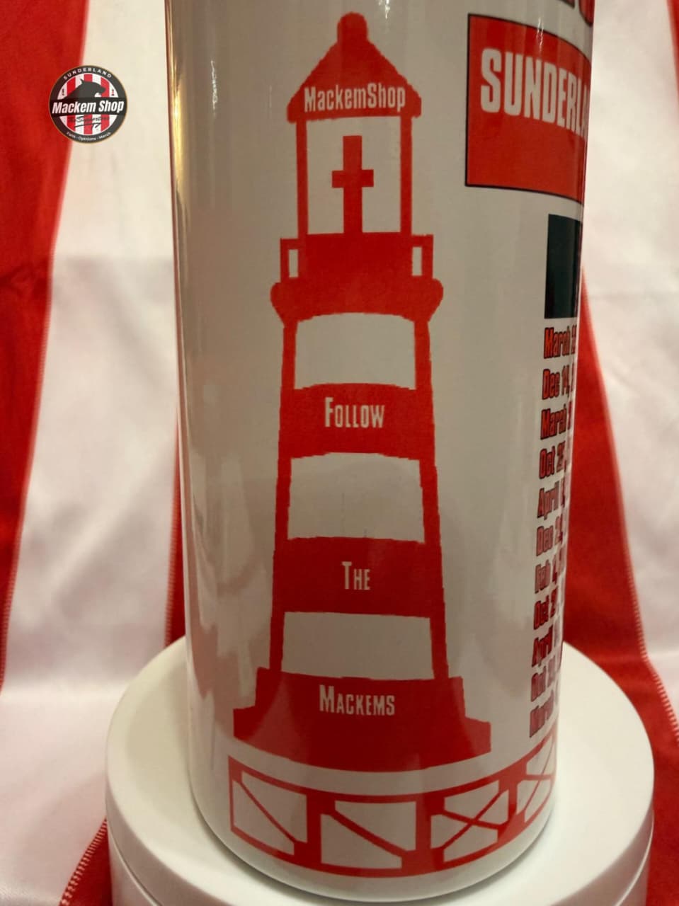 White mug with red lighthouse design and text on a white background