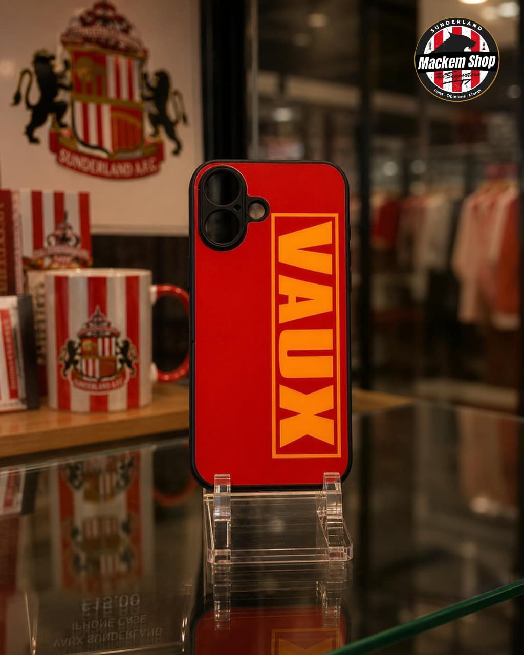 Red iPhone case with 'VAUX' branding in a store setting